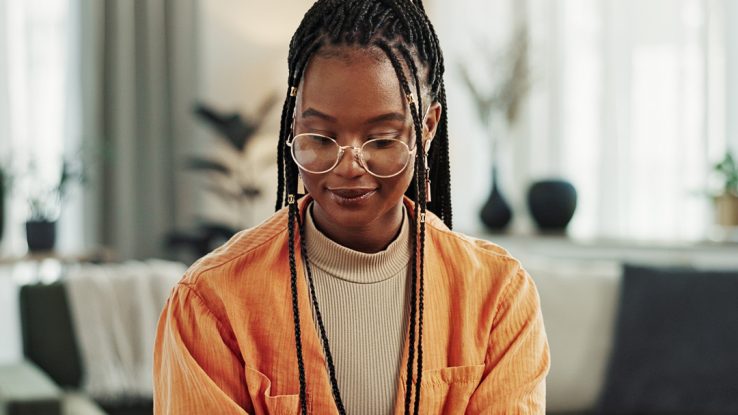 Black woman, typing in home office and laptop for remote work, social media or blog research in apartment. Freelance girl at desk with computer writing email, website post and online chat in house.